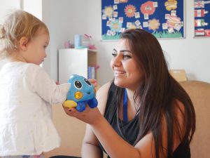 Staff member playing with little girl