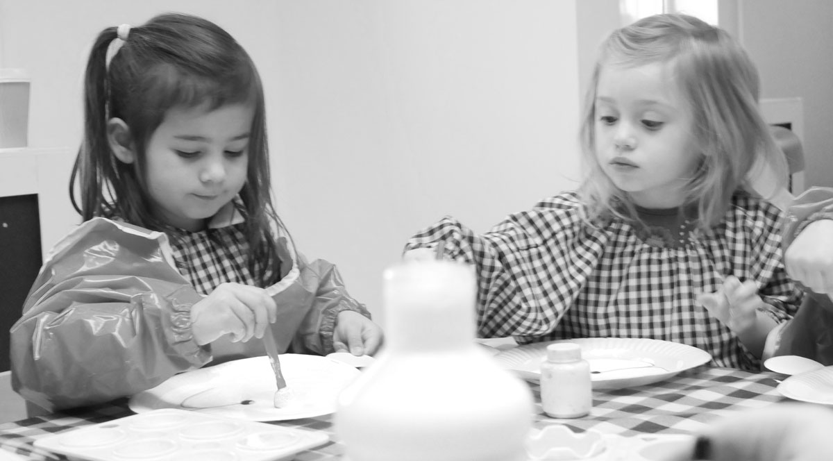 Two girls painting at Hove Village Day Nursery