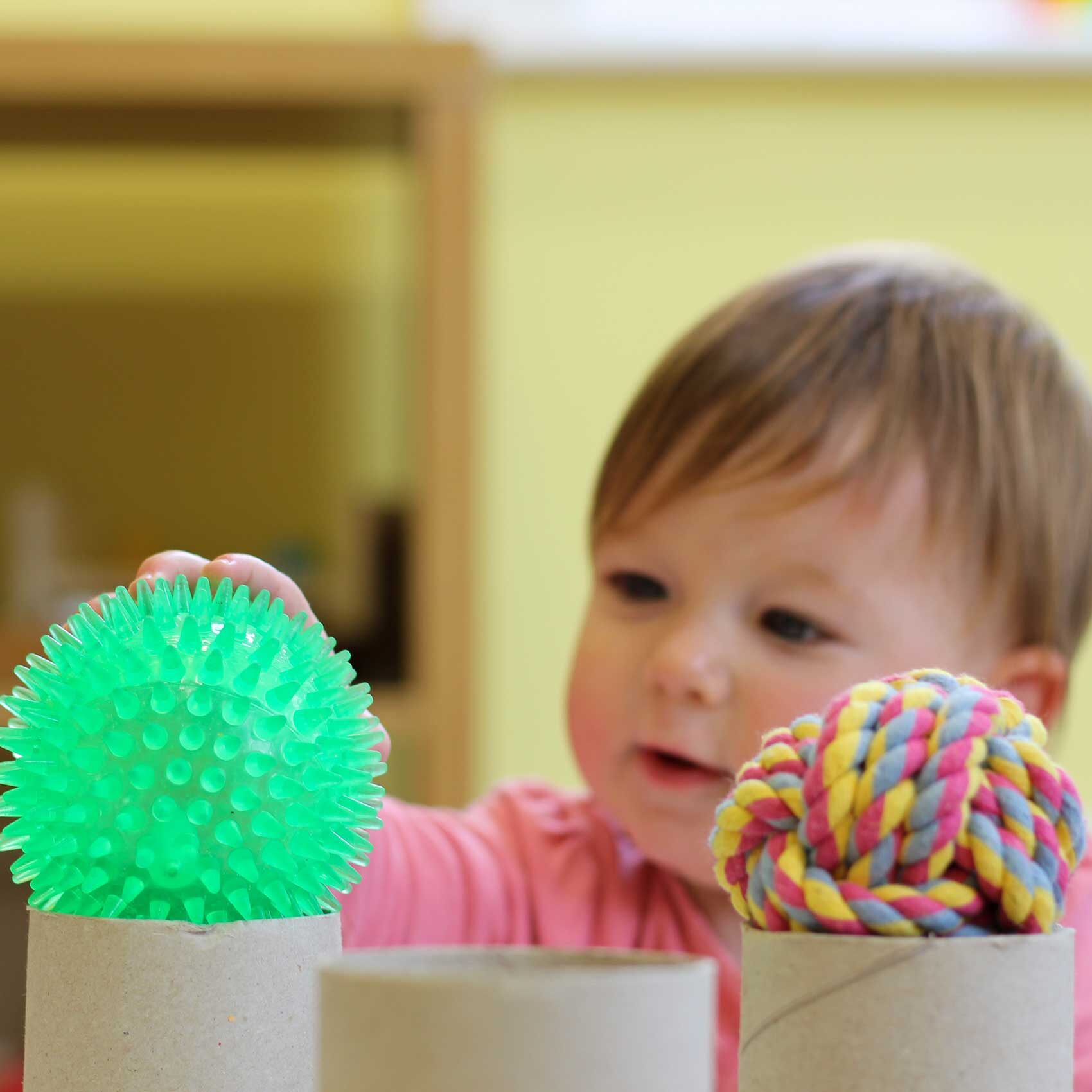 baby reaching for colourful ball